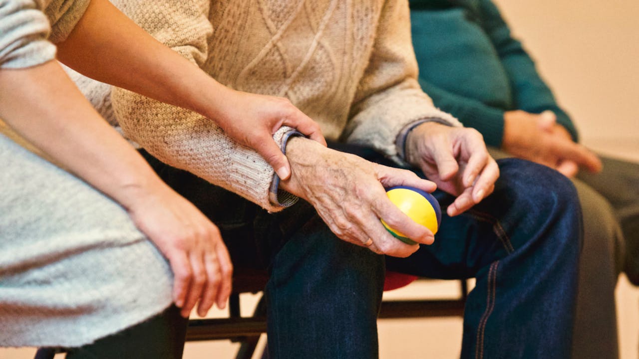 Crafting Captivating Headlines: Your awesome post title goes here An elderly person receives support from a caregiver, holding hands indoors, showcasing compassion.